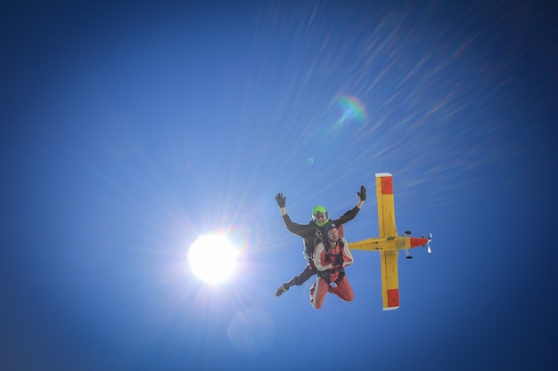 Salto de pára-quedas em conjunto com os primeiros segundos de queda livre com o sol e o avião.