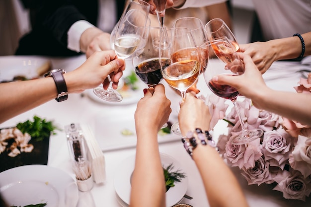 ¡Salud! Grupo de personas animando con flautas de champán con el interior de la casa en el fondo.