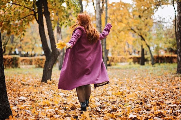 Salud mental en otoño mujer pelirroja feliz sosteniendo hojas de otoño de arce amarillo