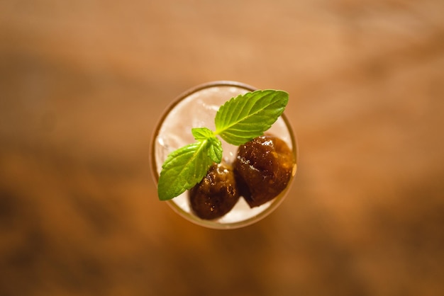 Saludable bebida fría de refresco de ciruela y miel con hielo en vaso refresco de cóctel de verano con jugo de frutas tropicales son dulces frescos y frescos con fondo de café café