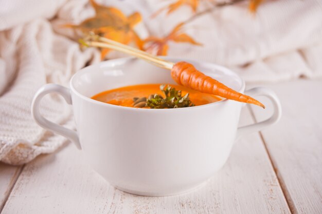 Saludable comer sopa de crema de zanahoria.