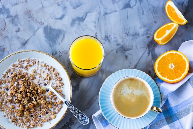 Un saludable desayuno de muesli de chocolate con café, naranjas y jugo.