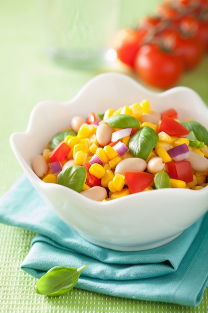 Saludable ensalada de maíz con cebolla de tomate albahaca blanca