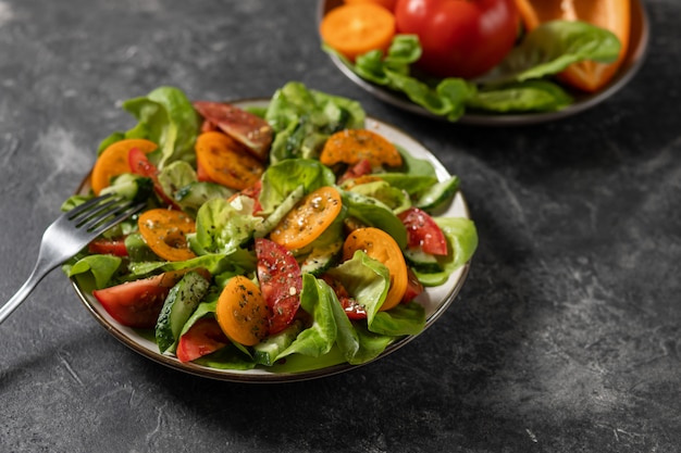 Saludable ensalada de vegetales frescos de tomates, pepinos, cebollas, espinacas, lechuga en un plato. Menú de dieta Vista desde arriba.