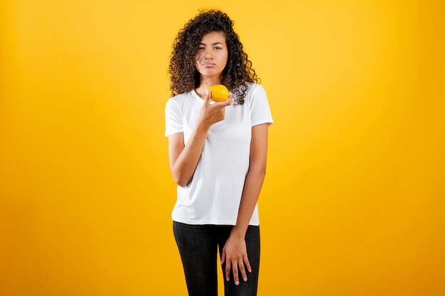 Saludable joven negra africana con limón aislado sobre amarillo