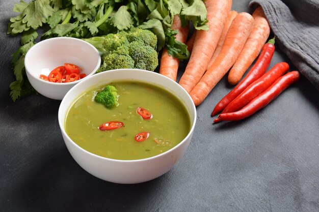 Saludable Vegano Cremoso puré de sopa de verduras mezcladas con brócoli, apio, guisantes y zanahorias.