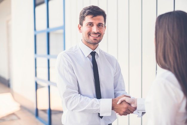 El saludo de hombre y mujer de negocios.