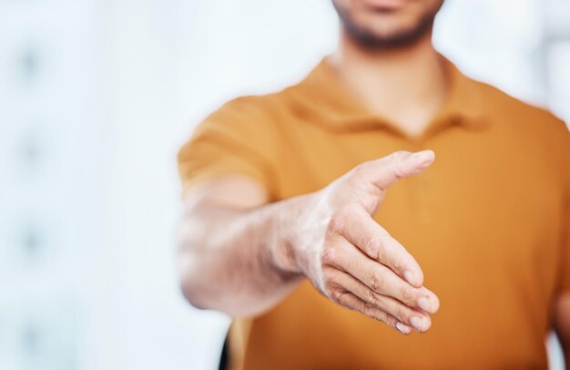 Saludo profesional y hombre de negocios con un gesto de apretón de manos para un acuerdo de bienvenida o asociación Oficina corporativa y empleado masculino extendiendo una mano para estrechar la mano de acuerdo en el lugar de trabajo