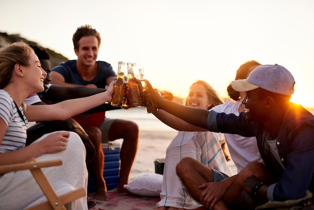 Saludos a los amigos que se convirtieron en familia Foto de un grupo de amigos disfrutando de bebidas en la playa