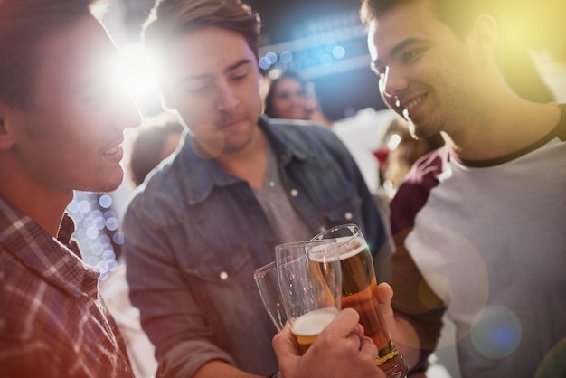 Saludos chicos Captura recortada de chicos brindando con cervezas en una fiesta