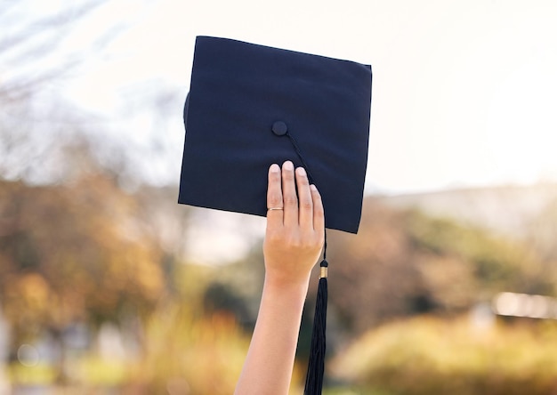 Saludos a la universidad, vamos al futuro Foto de una mujer irreconocible sosteniendo su gorra de graduación en la universidad