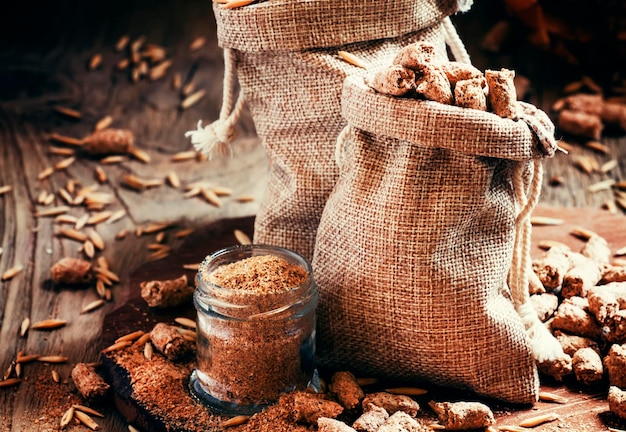 Salvado de avena saludable en bolsas de lona enfoque selectivo de fondo de madera vintage