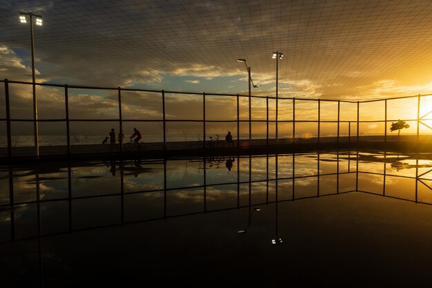 Salvador Bahía Brasil 05 2021 de diciembre Silueta de personas haciendo ejercicio en el borde de la playa Rio Vermelho en Salvador Bahía contra la puesta de sol amarilla