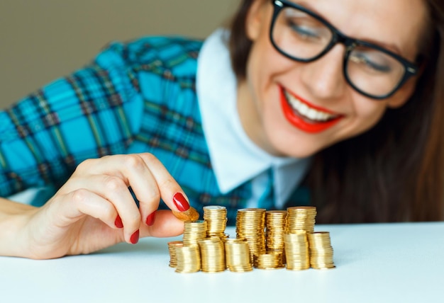 Salvando a la mujer sonriente apilando monedas de oro en columnas