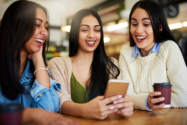 Salvei alguns vídeos engraçados para mostrar a vocês dois foto recortada de um grupo de jovens amigos saindo em um café