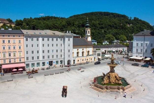 Salzburgo, Áustria-27 de junho de 2016: Vista panorâmica da Praça de Salzburgo, Áustria, Europa. Dia de verão com nuvens azuis no céu. Pessoas caminham no centro do parque