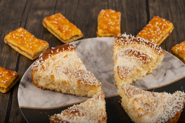 Foto salzige cracker-brezeln mit geschnittenem kuchen auf holztisch gelegt.