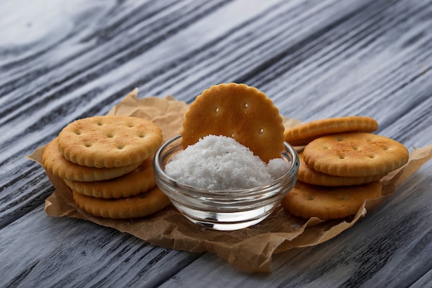 Salziger Cracker und Salz auf hölzernem Hintergrund