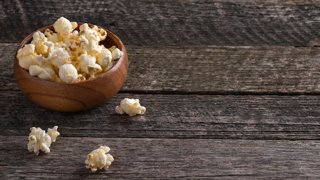 Salziges Popcorn in einer Holzschale im rustikalen Stil. Speicherplatz kopieren