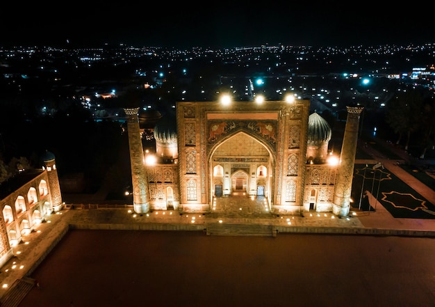 Foto samarkand uzbequistão vista aérea da madrassa ulug bek colorfull registan square à noite