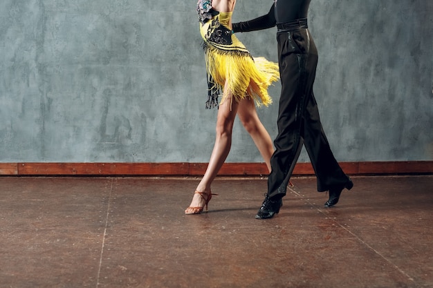 Samba de dança de salão. Jovem casal com roupas amarelas e pretas dançando.