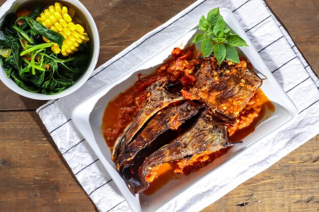 Sambal Santan Ikan Panggang oder Ikan Pari Asap ist geräucherter Rochenfisch, der mit würziger Kokosmilch serviert wird