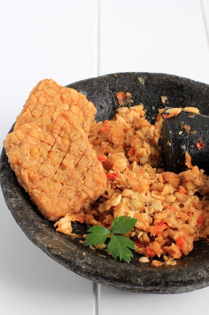 Sambel Tempeh Tempeh con chile en molinillo de piedra Menú delicioso diario popular en Indonesia Cerrar