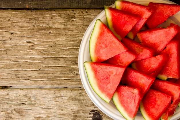 Samenlose Wassermelone schnitt in die Keile, die auf Teller dienen