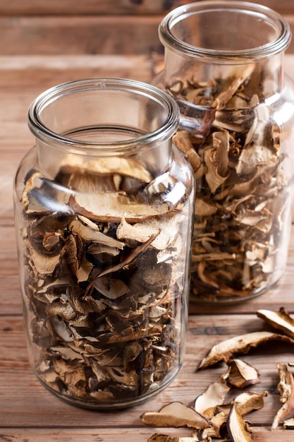 Sammeln und trocknen Sie Pilze im Herbst Steinpilze in einem Glas eine köstliche Zutat für Saucen und Gulasch auf einem Holztisch