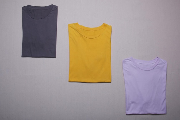 Sammlung von gefalteten T-Shirts Mockup auf grauem Hintergrund Flache Lay-Tees-Vorlage