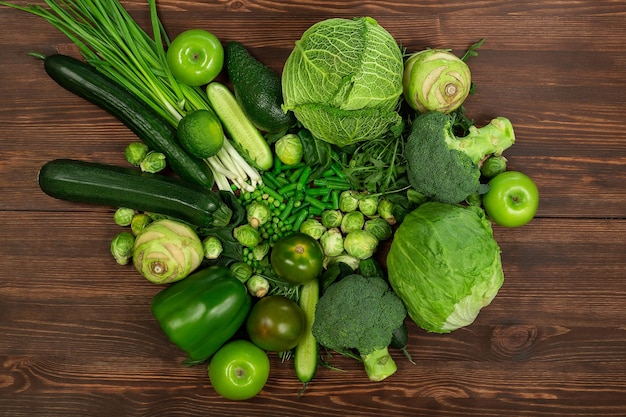 Sammlung von grünen Gemüseprodukten auf dunklem Hintergrund Broccolini-Avocado-Kürbis-Chili-Trauben Teil des flach gelegten Overhead-Sets