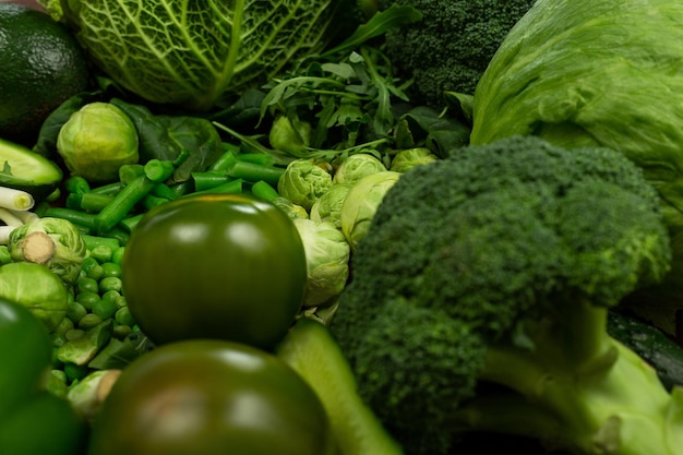 Sammlung von grünen Gemüseprodukten auf dunklem Hintergrund Broccolini-Avocado-Kürbis-Chili-Trauben Teil des flach gelegten Overhead-Sets