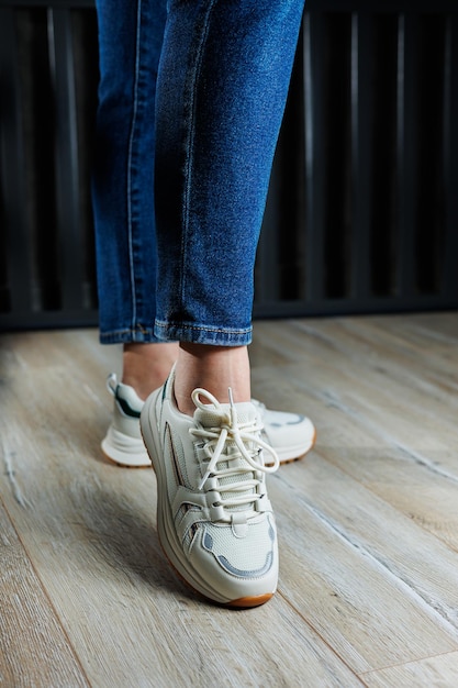 Sammlung von Lederschuhen für Frauen Weibliche Beine in Leder weißen Casual-Sneakers Stilvolle Sneakers für Frauen