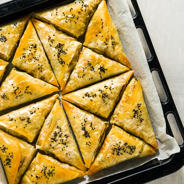 Samosa india al horno hecha con filo con patatas picantes y verduras con semillas de sésamo negro. comida rápida tradicional callejera