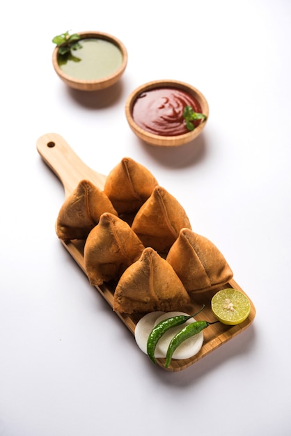 Samosa-Snack serviert mit Tomatenketchup und Minz-Chutney