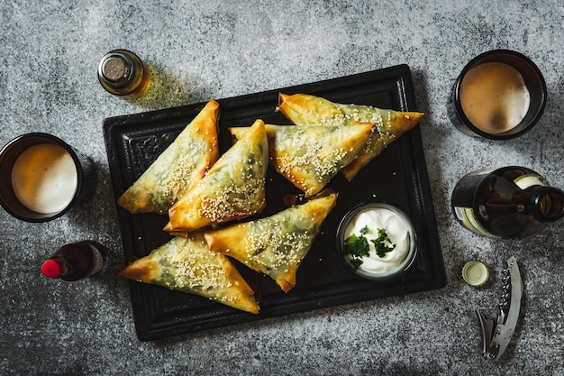 Samosa en un tentempié de mesa oscura para cerveza