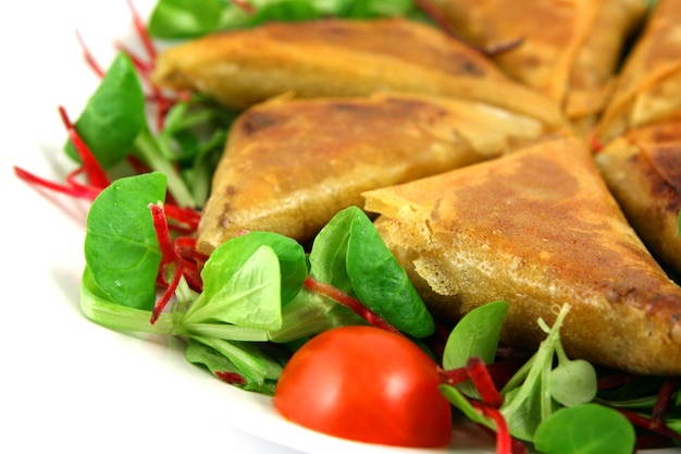 Samosas y espacio en blanco de ensalada a la izquierda