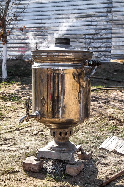 Foto samovar de metal para aquecimento de água com madeira