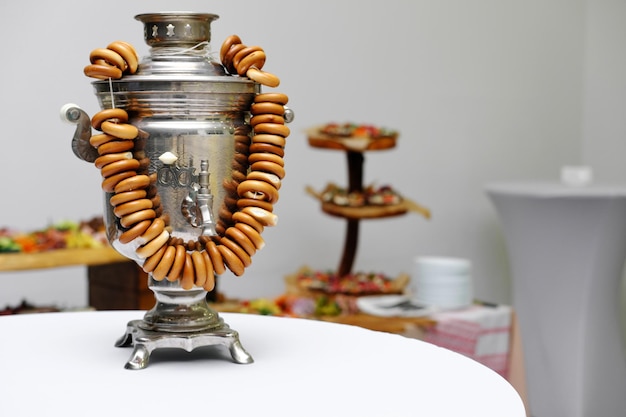 Samovar ruso tradicional con un montón de bagels en sala de luz blanca