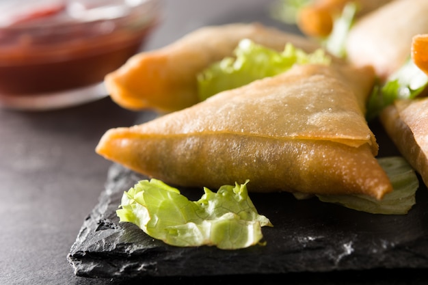 Samsa oder Samosas mit Fleisch und Gemüse auf Schwarz. Nahansicht