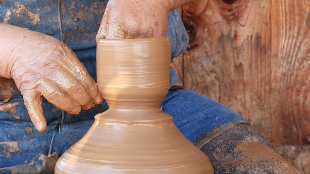 SAN DIEGO, KALIFORNIEN USA - 5. JANUAR 2020: Töpfer, der in der mexikanischen Altstadt arbeitet, roher Ton auf Töpferscheibe. Menschenhände, Keramiker bei der Modellierung handgefertigter Tonwaren. Handwerker, der Keramik schafft.