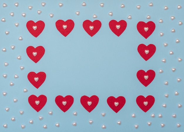 San Valentín azul con corazones rojos y perlados.
