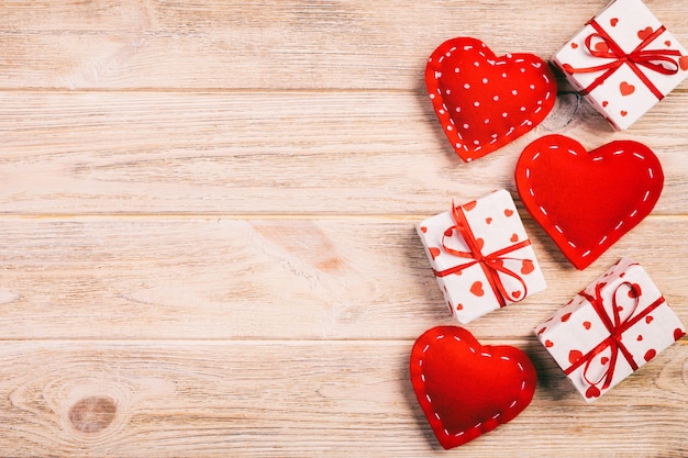 San Valentín presente en papel con corazones rojos y caja de regalos