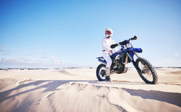 Sand-Motorsport und Mann mit Motorrad für Adrenalin-Abenteuer und Freiheit in der Wüste. Extreme Action-Herausforderung und männliche Person auf dem Fahrrad auf Dünen für Trainingsübungen und Rennen oder Wettkämpfe