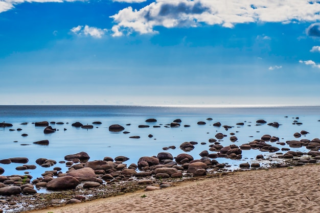 Sand Stone Boulders Seascape com águas calmas contra o céu azul