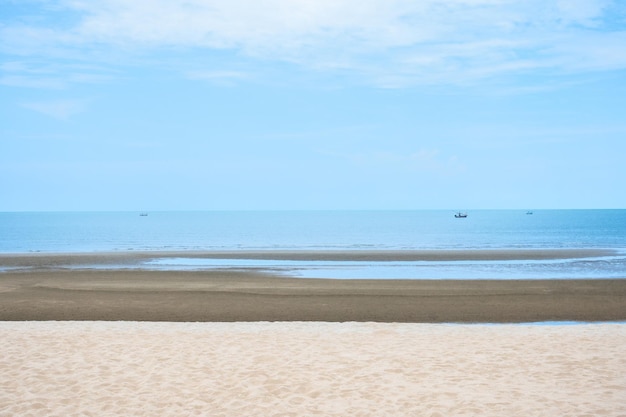 Foto sand und sommermeer mit himmel an der küste schöne naturlandschaft im freien mit einem fischerboot