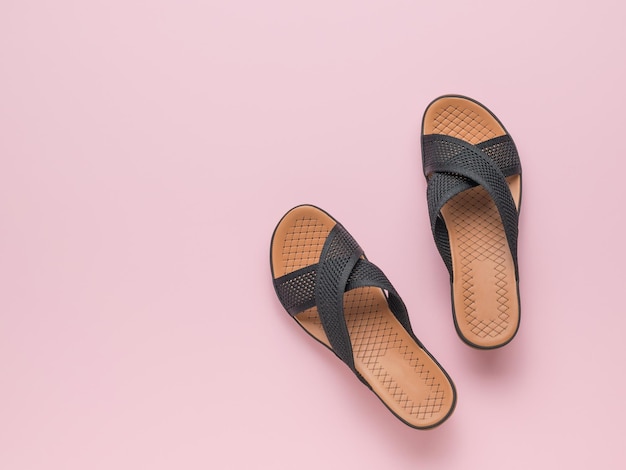 Sandalias clásicas de verano para mujer sobre un fondo rosa Concepto mínimo de zapatos de mujer de verano