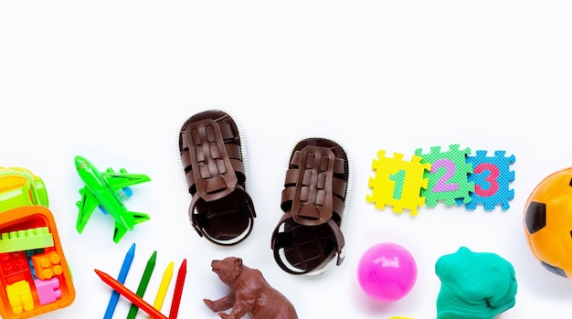 Sandalias de cuero marrón para niños con coloridos juguetes.