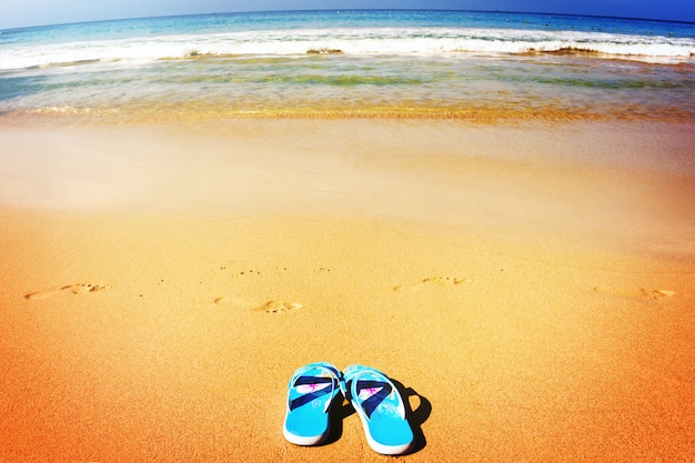 Sandálias de praia na costa arenosa tropical