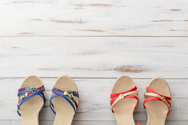 Sandalias femeninas de concepto de fondo de verano en superficie de madera clara